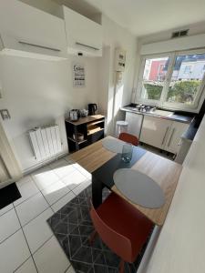 a kitchen with a table and chairs in a room at Beau studio plein centre ville in Beauvais