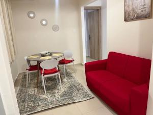 a living room with a red couch and a table at Elena s apartment in Megara