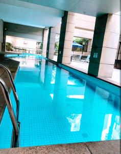 una gran piscina de agua azul en un edificio en Hotel M-RCURE Times Square MOEMA - Diamond Deluxe Duplex - Business Edition - Executive Class - By LuXXoR en São Paulo