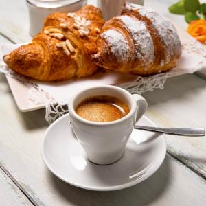 a cup of coffee and croissants on a table at Case Vanella Grande aspra bagheria in Bagheria