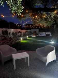 two chairs and a table in a yard at night at Acquamarina in Gaeta