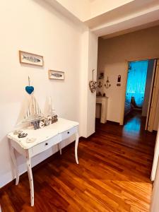 een witte kamer met een witte tafel en houten vloeren bij Dodo House La Spezia in La Spezia