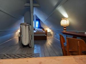 an attic room with a bed and a table at Hexen Haus in Burghaslach