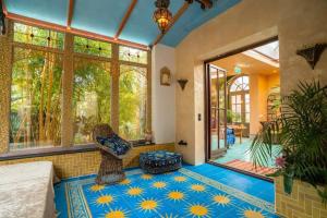 a bedroom with a blue and yellow floor and windows at Riad Agraba, 1001 nights in Lomm