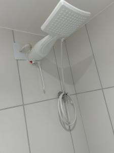 a hairdryer hanging from the corner of a bathroom at M.APTO barra funda in São Paulo