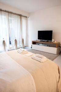 a bedroom with two beds and a flat screen tv at GINNY HOUSE VENEZIA in Dolo