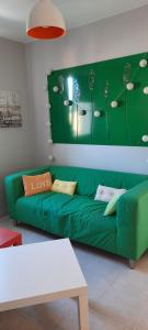 a green couch in a living room with a green wall at Studio situé centre ville in Parthenay