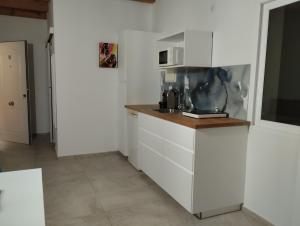 cocina con armarios blancos y microondas en Apartamentos y Habitaciones KAI MARBELLA, en Marbella