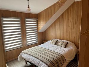 een slaapkamer met een bed en 2 ramen bij ARCA HOTEL BOUTIQUE in Achao