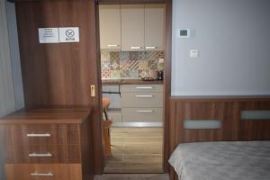 een kleine slaapkamer met een bed en een keuken bij Apartament Nicolae Iorga RHBM in Baia Mare