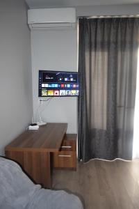 een slaapkamer met een houten bureau en een televisie. bij Apartament Nicolae Iorga RHBM in Baia Mare