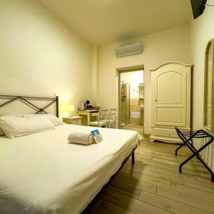 a bedroom with a large white bed and a desk at SG Rooms - Casa Laura in Peschiera del Garda