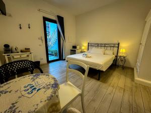 um quarto com uma cama, uma mesa e uma janela em SG Rooms - Casa Laura em Peschiera del Garda