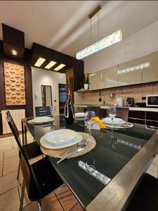 a kitchen with a table with plates and wine glasses at Center Apartment Easy in Tirana
