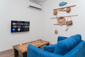 - un salon avec deux chaises bleues et une table dans l'établissement Le Rêve Tropical proximité plage et commerces, à Punaauia