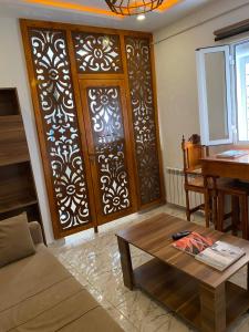 a living room with a wooden door and a table at Appartement coeur de ville Tunis in Tunis