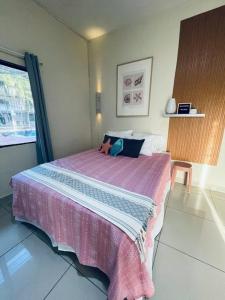 1 dormitorio con 1 cama grande con manta rosa en Olas de Sol en La Libertad