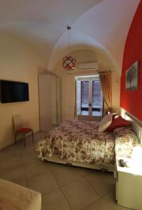 a bedroom with a large bed and a tv at Casa San Brasi di Mariano e Lucia in Acireale