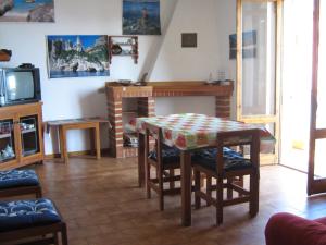 a living room with a table and a fireplace at Casa Secci in Santa Maria Navarrese