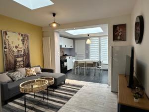 een woonkamer met een bank en een tafel bij Maison Lilloise 3 chambres in Lille