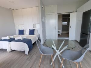 een slaapkamer met 2 bedden en een glazen tafel en stoelen bij Jobeal Ocean in Santa Cruz de la Palma