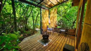 a porch of a cabin with a table and chairs at El Jardin, Eco Cabañas Boutique in San Alfonso