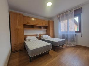 a bedroom with two twin beds and a window at Apartamento céntrico Llanes in Llanes