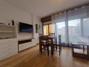 a dining room with a table and chairs and a television at Apartamento céntrico Llanes in Llanes