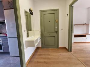 a room with a green door in a kitchen at Apartamento céntrico Llanes in Llanes