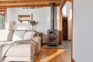 a living room with a couch and a wood stove at Buttons By The Beach - beach house on King Island 