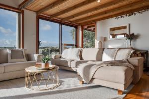 a living room with two couches and a table at Buttons By The Beach - beach house on King Island 