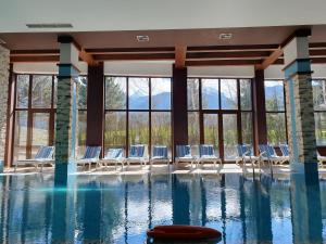 a swimming pool with chairs and windows at Apartment ZAX B7 in Terra Complex in Bansko