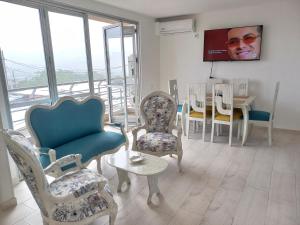 a living room with chairs and a tv and a table at Reserva del Peñón Girardot - Apartamento Vacacional Familiar Confort La Esmeralda in Girardot