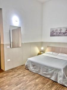 um quarto com uma cama grande e piso em madeira em B&b al centro storico giovanna em Marsala