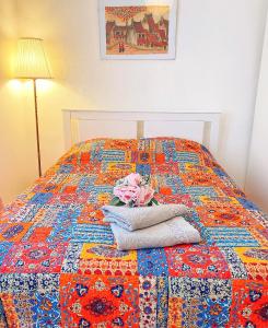 a bed with a colorful quilt on top of it at NICE APPARTEMENT in Amboise