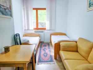 a living room with a couch and a table at Zlatni Pir Rooms and Apartments in Sarajevo