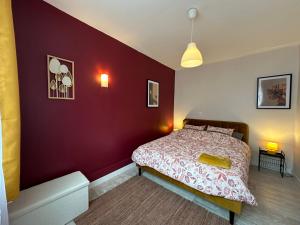 - une chambre avec un mur rouge et un lit dans l'établissement Maison Lilloise 3 chambres, à Lille