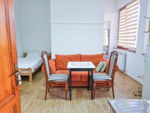 a living room with a couch and a table and chairs at Zlatni Pir Rooms and Apartments in Sarajevo