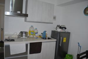 a small kitchen with a sink and a refrigerator at 227 Santorini Azure Urban Resort Condo Unit in Manila