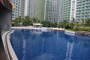 a large swimming pool in front of tall buildings at 227 Santorini Azure Urban Resort Condo Unit in Manila