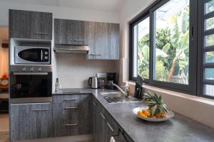 a kitchen with a bowl of fruit on a counter at Le Rêve Tropical proximité plage et commerces in Punaauia