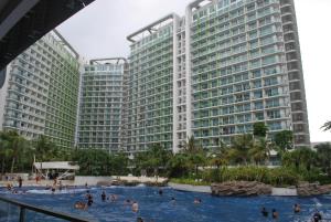 a swimming pool in front of two tall buildings at 227 Santorini Azure Urban Resort Condo Unit in Manila