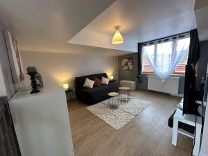 - un salon avec un canapé noir et une fenêtre dans l'établissement Maison Lilloise 3 chambres, à Lille