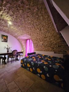 een slaapkamer met een bed in een stenen muur bij Gite 5 personnes SOLOGNE in Hargeville