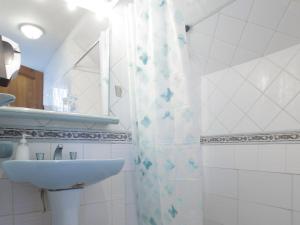 a bathroom with a sink and a shower curtain at Sandy Point B&B in Punta Arenas