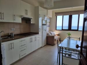 Una cocina con gabinetes blancos y una mesa en ella. en Jobeal Beach, en Santa Cruz de la Palma