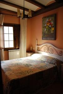 a bedroom with a large bed with a painting on the wall at Posada el Mirador in Frías de Albarracín