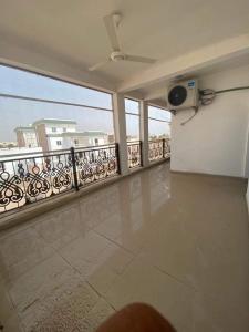 Cette grande chambre dispose d'un balcon avec vue sur un bâtiment. dans l'établissement IDMAN RESIDENCE, à Ambouli