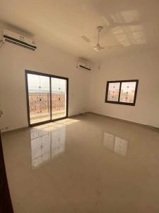 um quarto vazio com duas janelas e um quarto com paredes brancas em IDMAN RESIDENCE em Ambouli