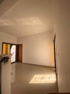 an empty room with a refrigerator and a hallway at IDMAN RESIDENCE in Ambouli